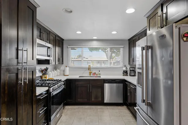 a kitchen with stainless steel appliances granite countertop a sink stove and refrigerator
