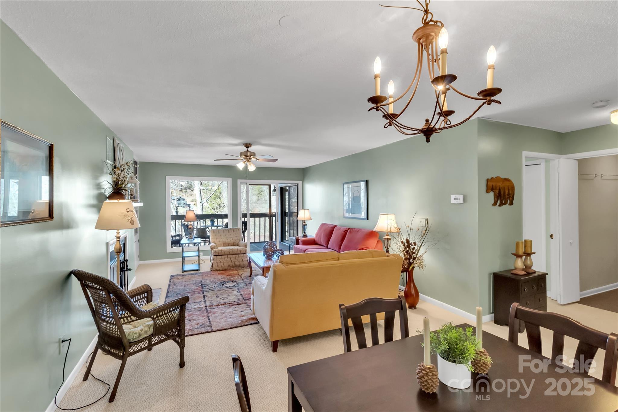 87 Willow Road, Unit C9 Waynesville, NC 28786 - Photo 7 of 31 a living room with furniture a chandelier and a dining room