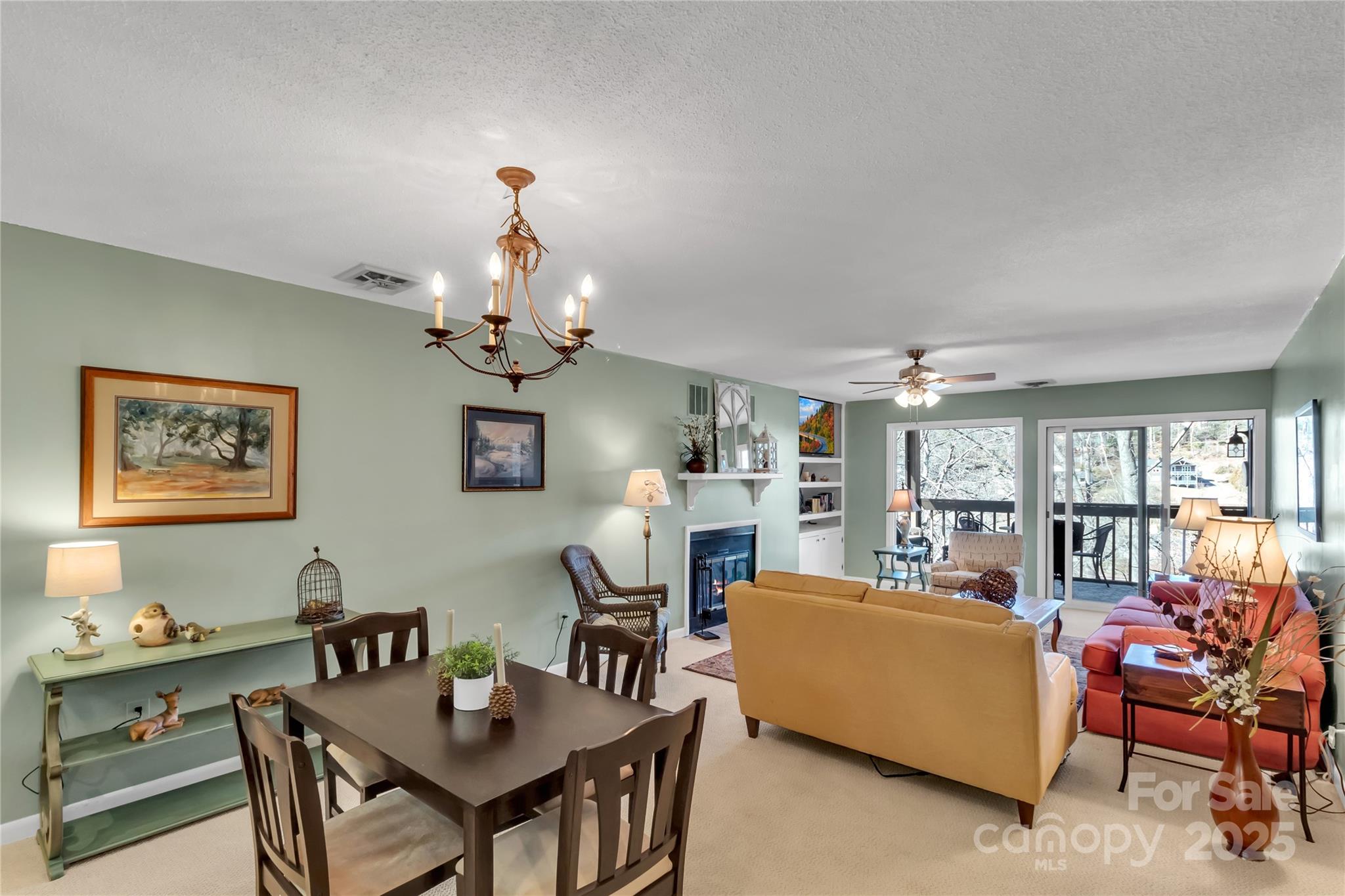 87 Willow Road, Unit C9 Waynesville, NC 28786 - Photo 8 of 31 a living room with furniture a chandelier and a dining table