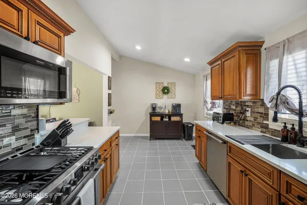 a kitchen with stainless steel appliances a sink stove and cabinets