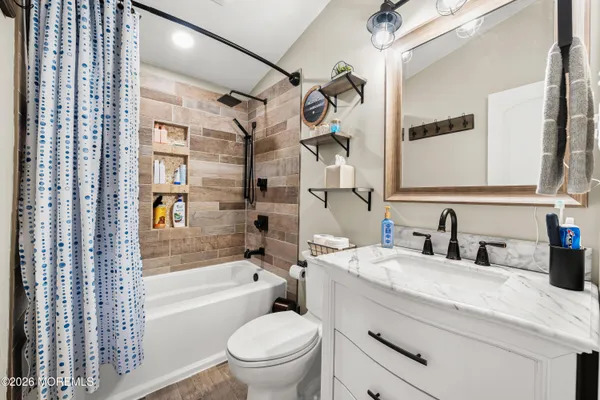 a bathroom with a granite countertop toilet sink and a bathtub