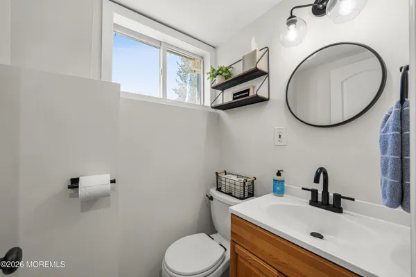 a bathroom with a toilet a sink and mirror