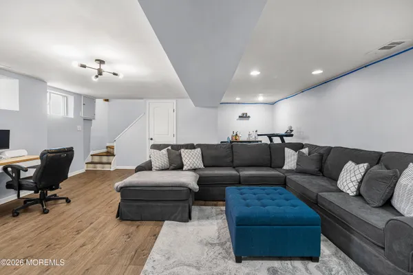 a living room with furniture and a wooden floor