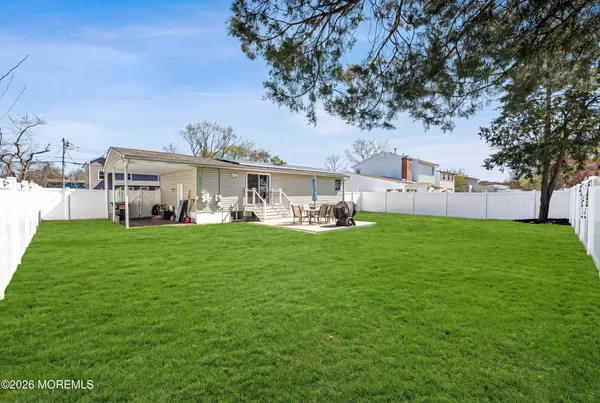 a view of a house with a big yard and large trees