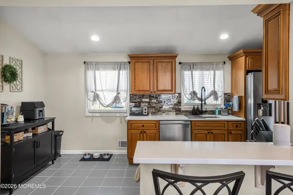 a kitchen with stainless steel appliances granite countertop a stove a sink and a refrigerator