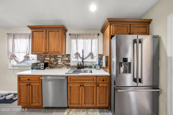 a kitchen with stainless steel appliances granite countertop a refrigerator a sink and a stove