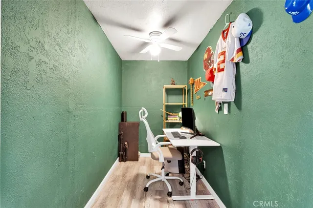 a view of a workspace with furniture and a fan