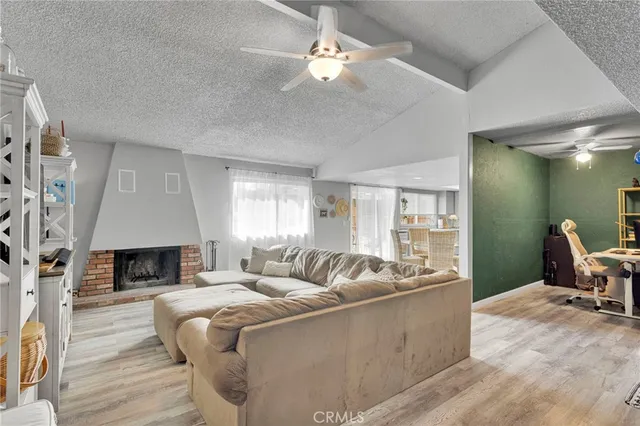 a living room with furniture a fireplace and a flat screen tv