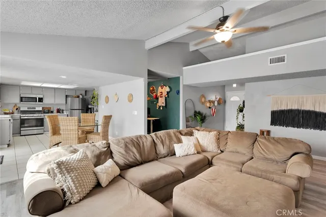 a living room with furniture and a view of kitchen