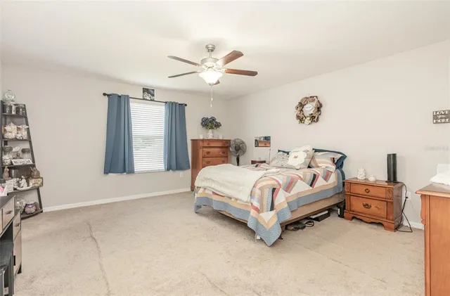 a bed sitting in a bedroom next to a window and a chandelier