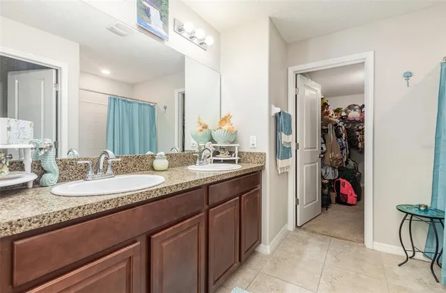 a en suite bathroom with a granite countertop sink and a mirror