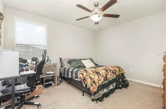 a bedroom with a bed a chair and a chandelier