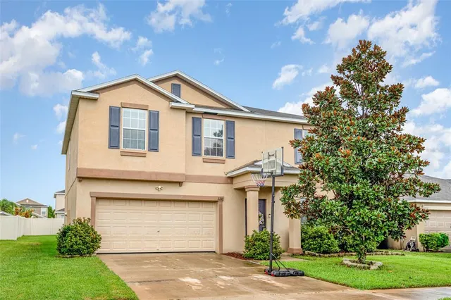 a front view of a house with a yard and garage