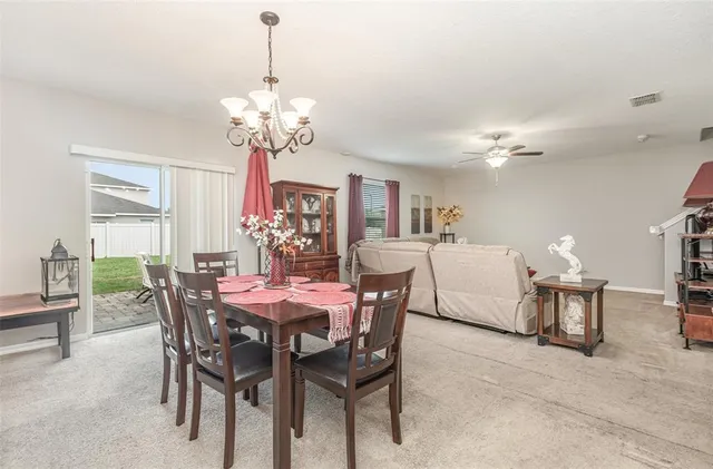 a view of a dining room with furniture and chandelier