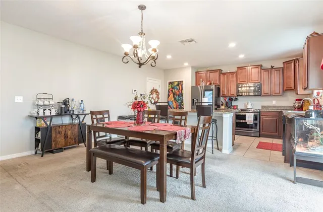 a view of a dining room with furniture and chandelier