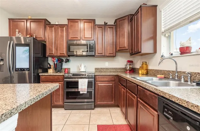 a kitchen with kitchen island granite countertop a sink counter top space appliances and cabinets