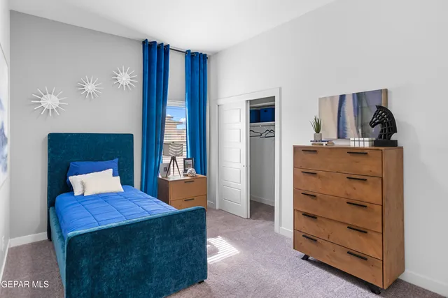 a bedroom with a bed and a painting on the wall