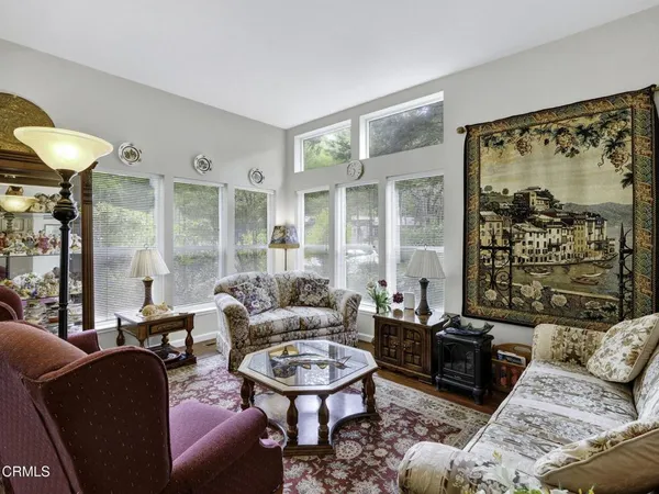 a living room with furniture a table and a large window