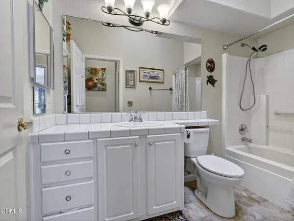 a bathroom with a granite countertop sink toilet a mirror a vanity and shower