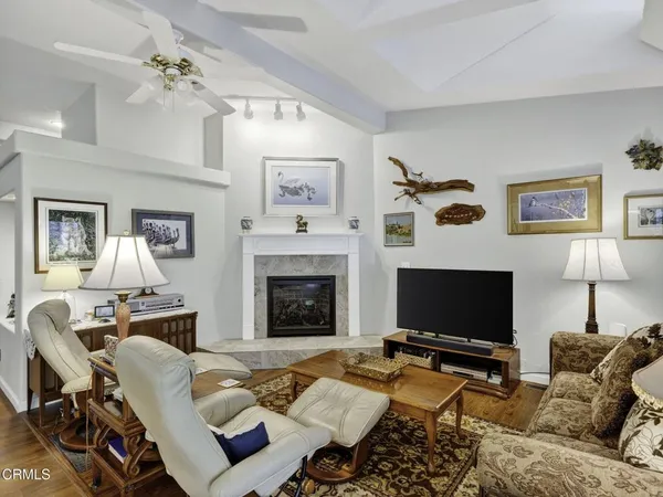 a living room with furniture a flat screen tv and a fireplace