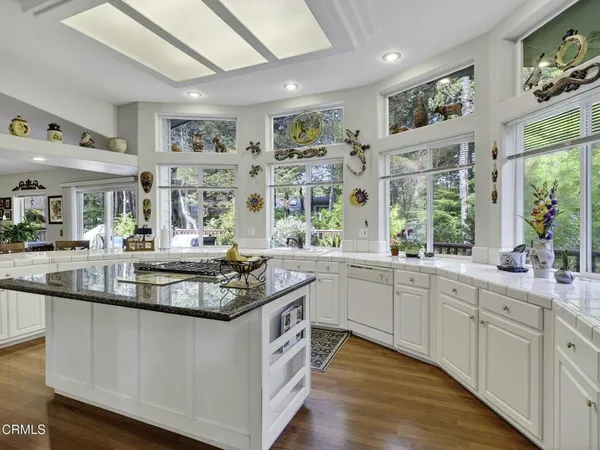 a kitchen with kitchen island granite countertop a sink and cabinets