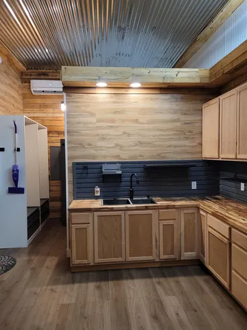 a kitchen with a wooden floor and cabinets