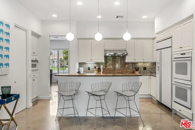 a kitchen with granite countertop a sink stove and refrigerator