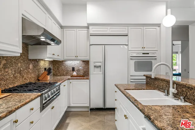 a kitchen with a sink dishwasher a stove and a microwave with cabinets