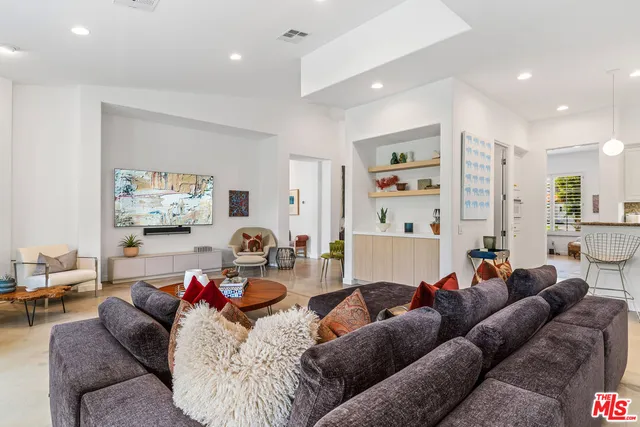 a living room with furniture kitchen and a dining table
