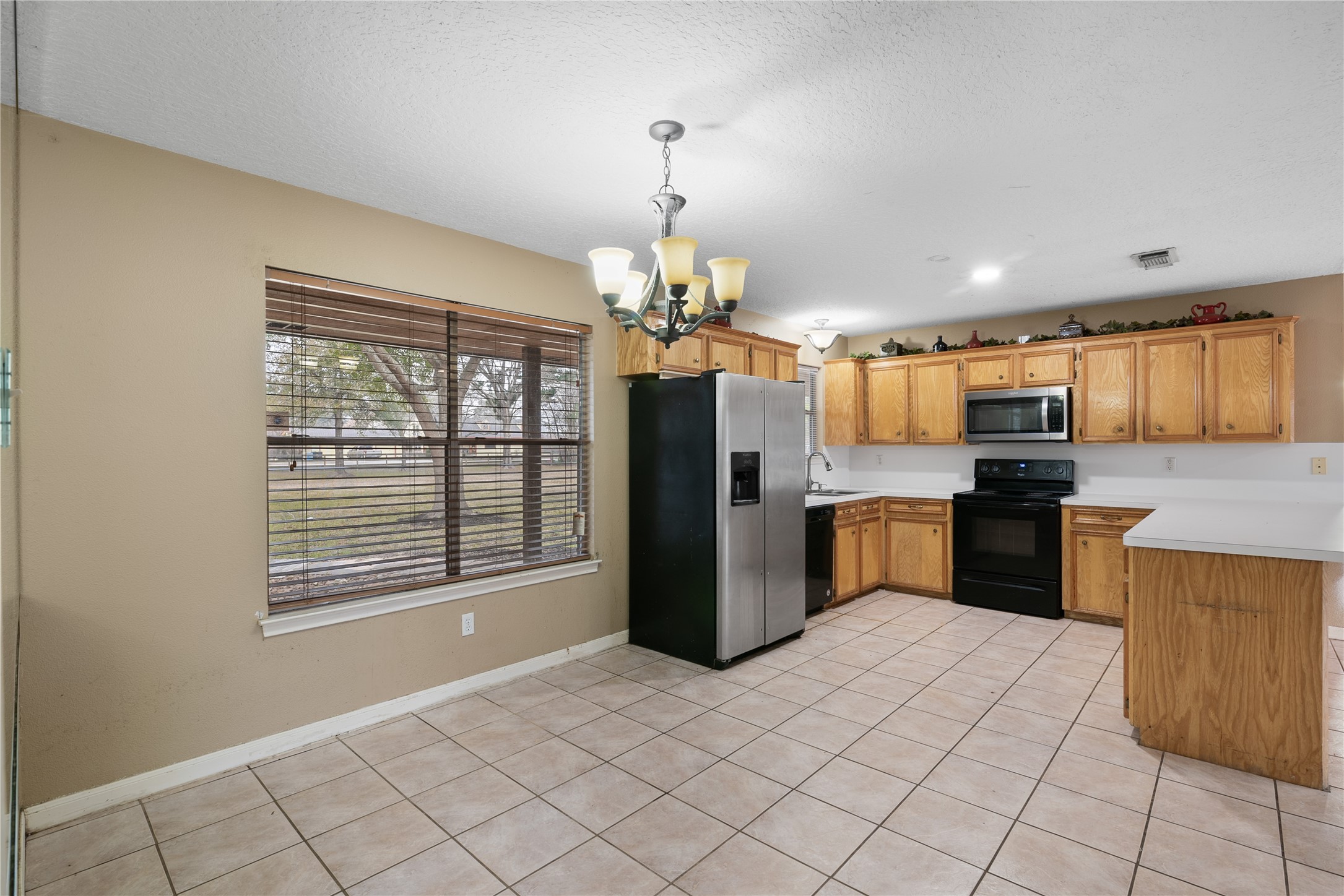 18914 Hamish Road Tomball, TX 77377 - Photo 18 of 39 a kitchen with stainless steel appliances kitchen island granite countertop a refrigerator and a sink