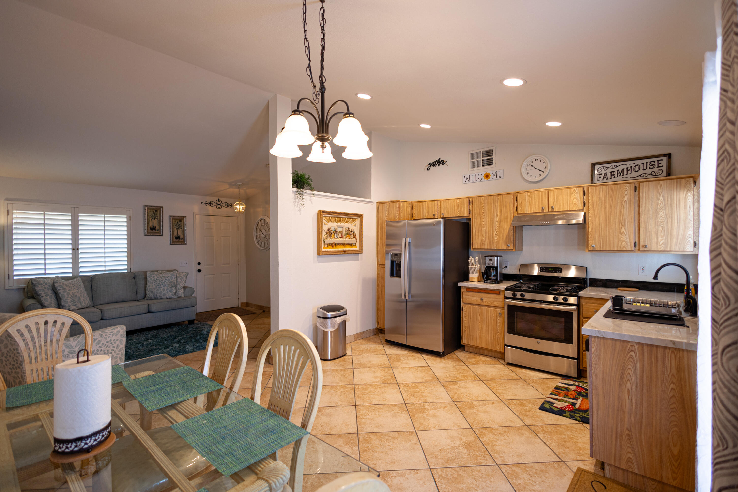 47800 Madison Street, Unit 37 Indio, CA 92201 - Photo 6 of 15 a kitchen with stainless steel appliances granite countertop a stove a refrigerator a kitchen island a sink dishwasher a dining table and chairs with wooden floor