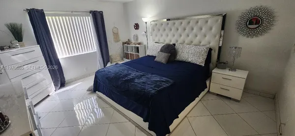 a bedroom with a bed and a mirror on the dresser