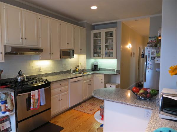 11 Hurd Road, Unit 2 Brookline, MA 02445 - Photo 7 of 18 a kitchen with kitchen island granite countertop a sink a stove and cabinets