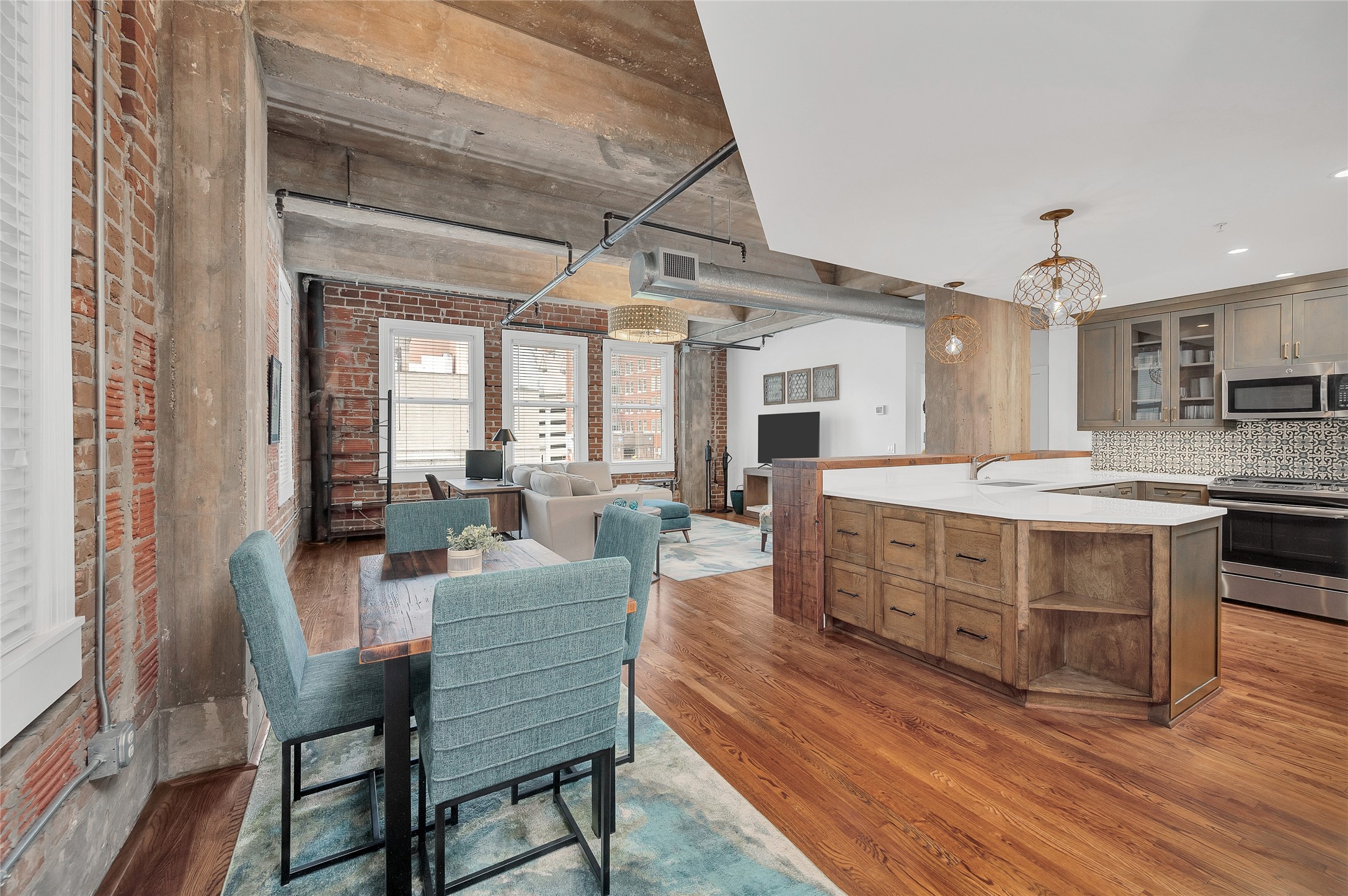 204 Travis Street, Unit 4A Houston, TX 77002 - Photo 1 of 34 a large kitchen with cabinets wooden floor and stainless steel appliances