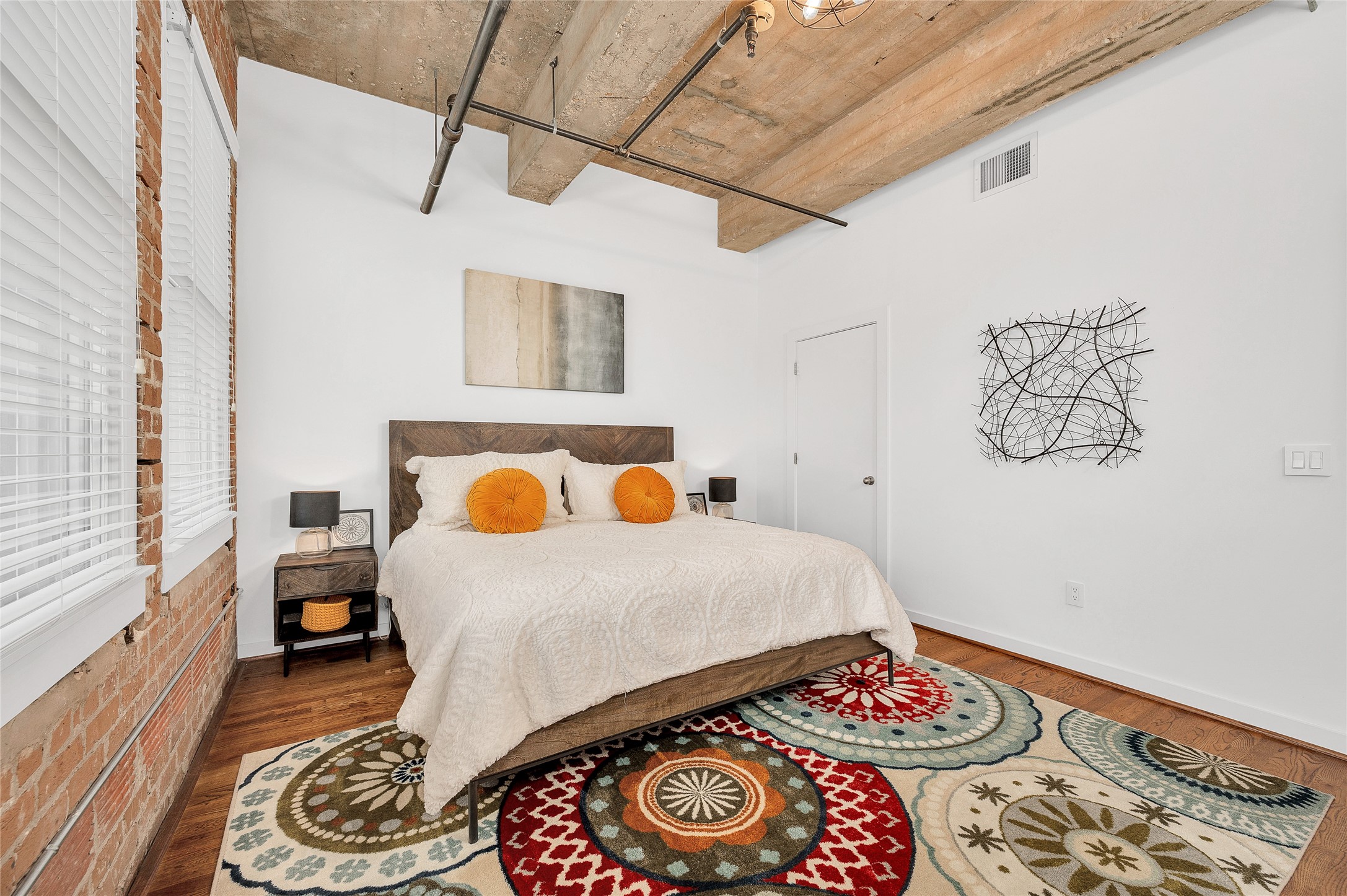 204 Travis Street, Unit 4A Houston, TX 77002 - Photo 13 of 34 a bedroom with a bed and a table with wooden floor