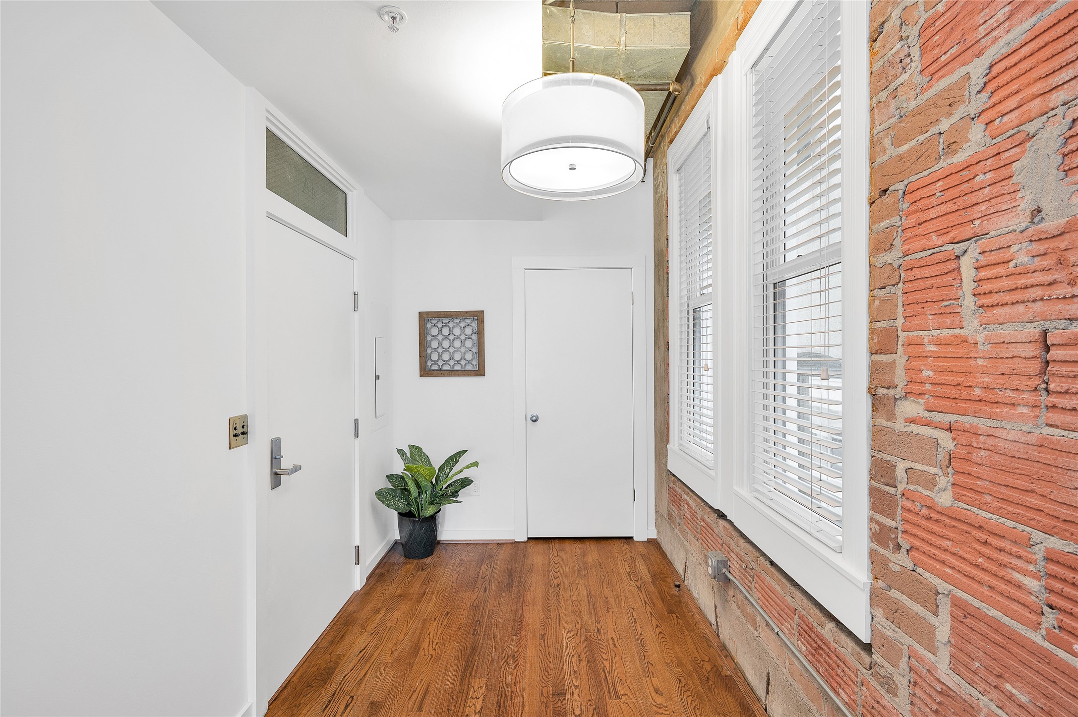 204 Travis Street, Unit 4A Houston, TX 77002 - Photo 6 of 34 a view of a hallway with wooden floor and a potted plant