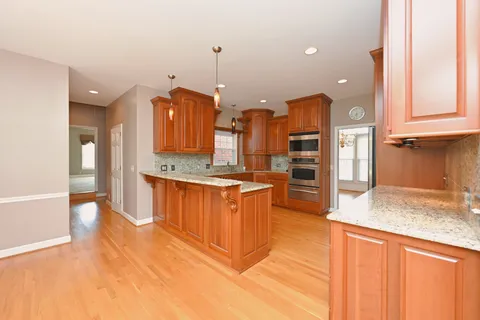a large kitchen with kitchen island granite countertop a large counter top stainless steel appliances and cabinets
