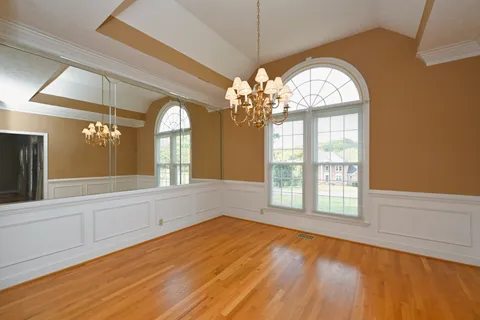 a view of a room with wooden floors and windows