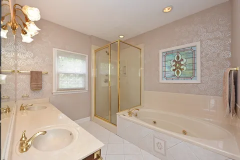 a bathroom with a tub sink and mirror