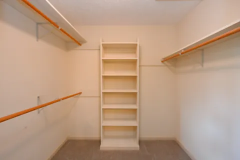 a view of walk in closet with empty racks