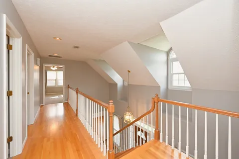 a view of a hallway with wooden floor and stairs