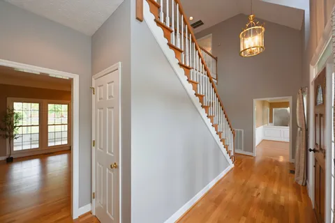a view of a hallway with wooden floor and staircase