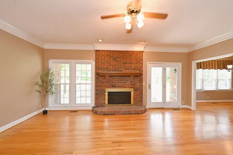 wooden floor fireplace and windows in an empty room
