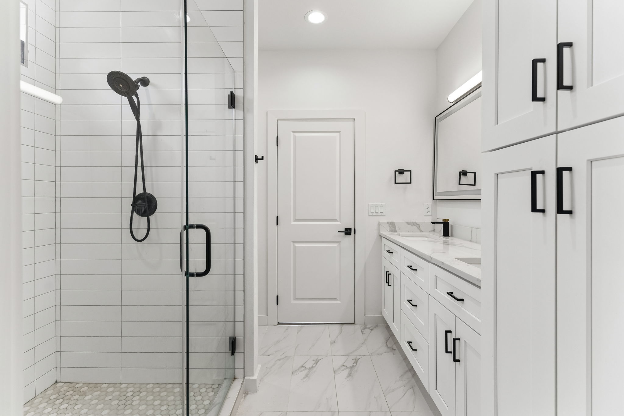 5305 Ledesma Road, Unit 1 Austin, TX 78721 - Photo 19 of 26 Shower enclosure with matte black fixtures, white subway tile surround, and pebble-style floor