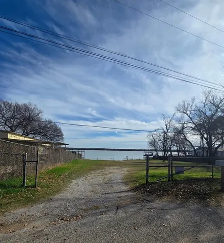 a view of a yard with wooden fence