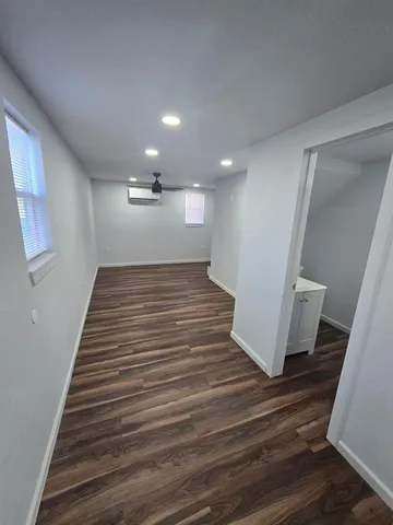 an empty room with wooden floor and staircase