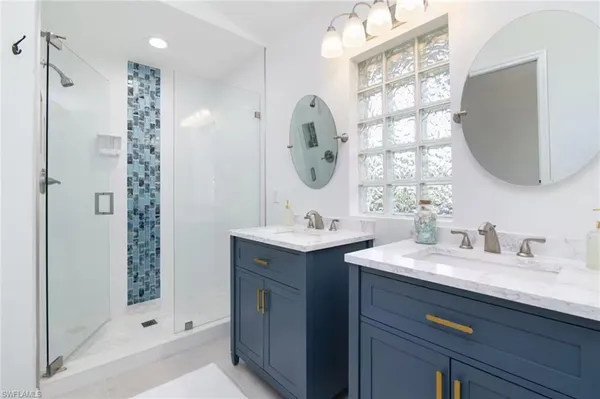 a bathroom with a double vanity sink mirror and shower