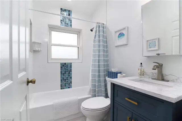 a bathroom with a sink toilet vanity and tub