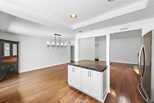 a kitchen with granite countertop a stove and a wooden floors