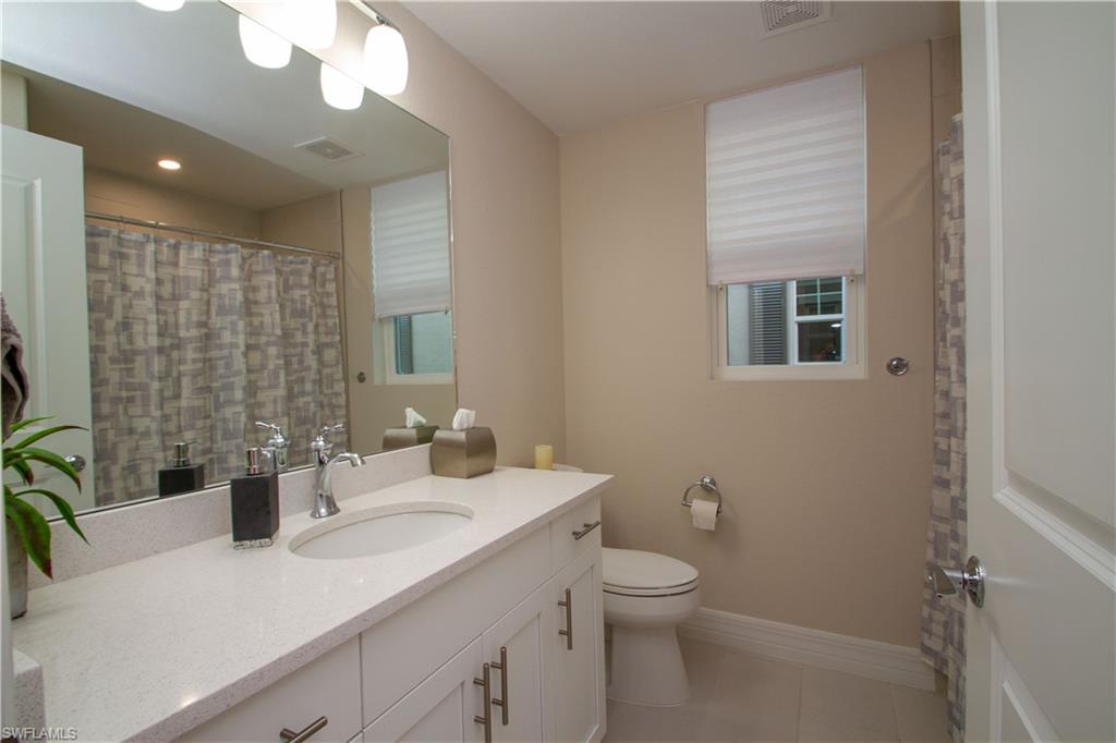 262 Indies Drive East, Unit 101 Naples, FL 34114 - Photo 18 of 32 a bathroom with a sink a toilet and shower